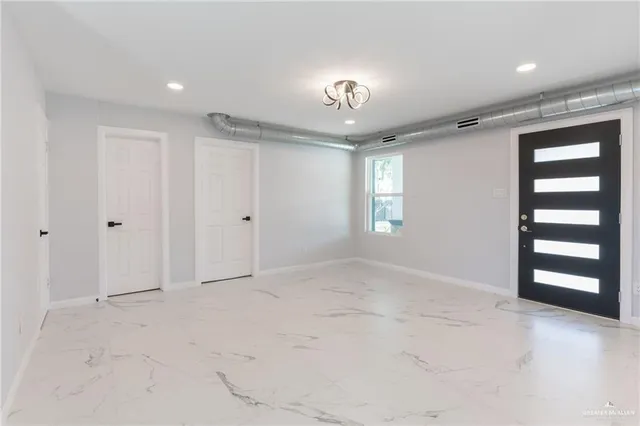 an empty room with windows and closet