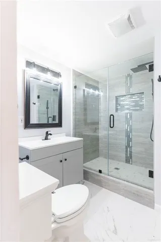 a bathroom with a shower sink mirror and toilet