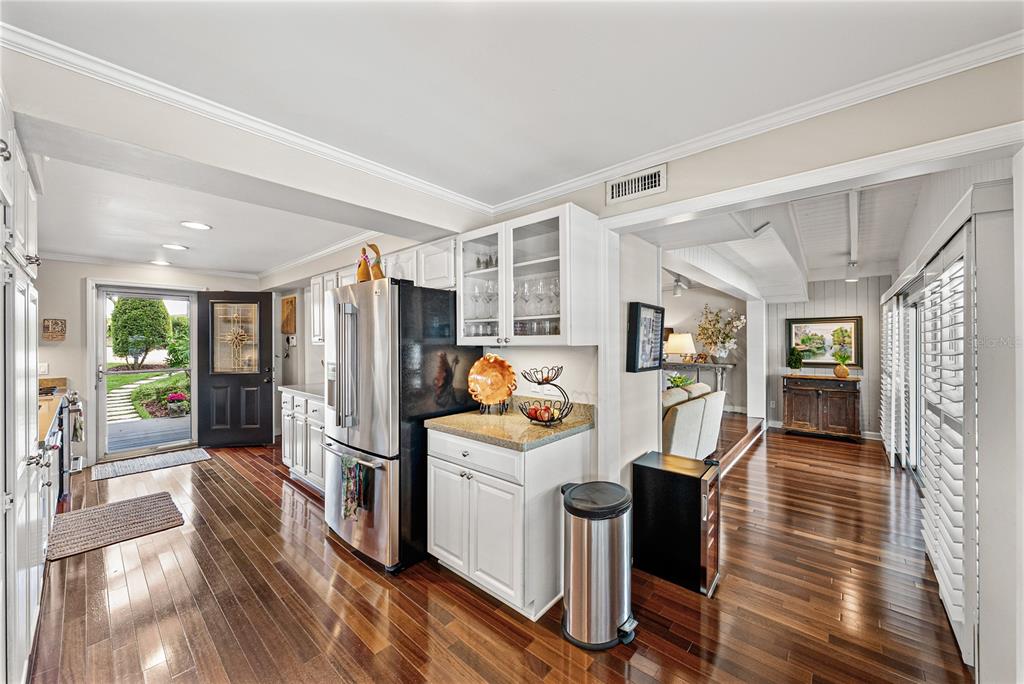 1075 Cody Cove Road Babson Park, FL 33827 - Photo 11 of 96 a kitchen with stainless steel appliances a refrigerator a stove a sink dishwasher and a dining table with wooden floor