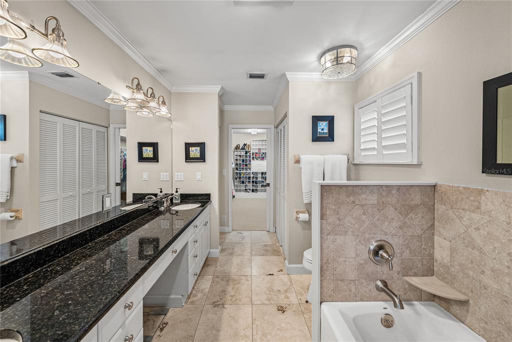 1075 Cody Cove Road Babson Park, FL 33827 - Photo 33 of 96 a spacious bathroom with a granite countertop sink a mirror a bathtub and shower