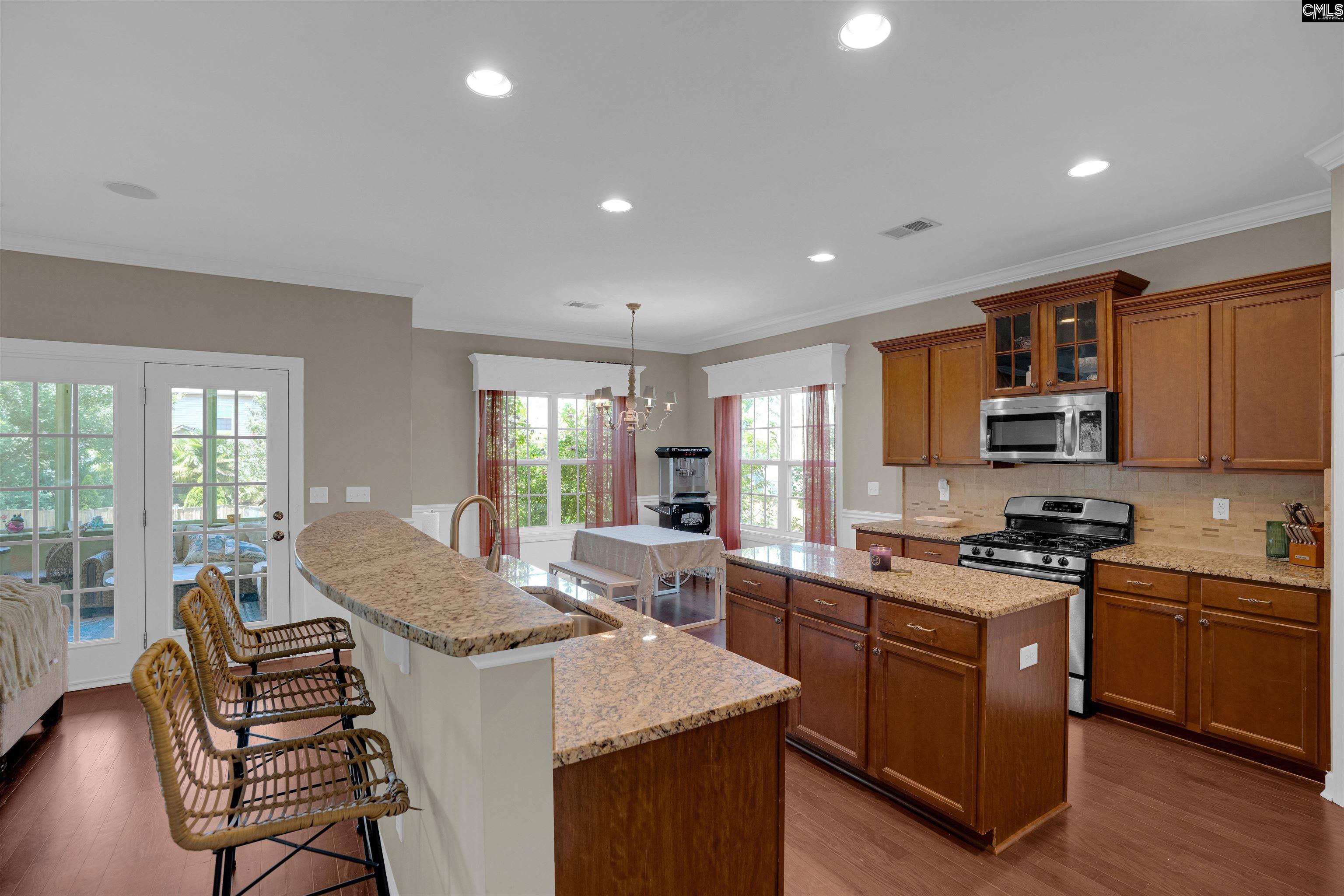 321 Asa Rose Lexington, SC 29072 - Photo 10 of 52 a kitchen with stainless steel appliances granite countertop a stove top oven a sink dishwasher a dining table and chairs with wooden floor