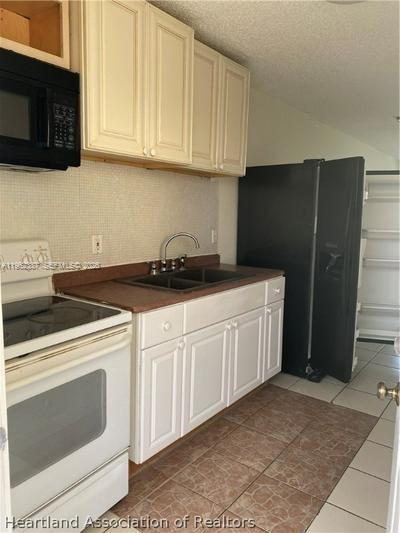 4131 Commercial Drive Sebring, FL 33870 - Photo 15 of 20 a kitchen with a sink and cabinets