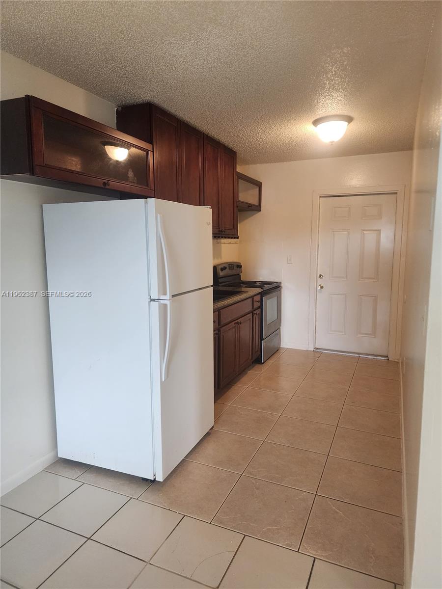 4131 Commercial Drive Sebring, FL 33870 - Photo 9 of 20 a kitchen with granite countertop a refrigerator and a sink