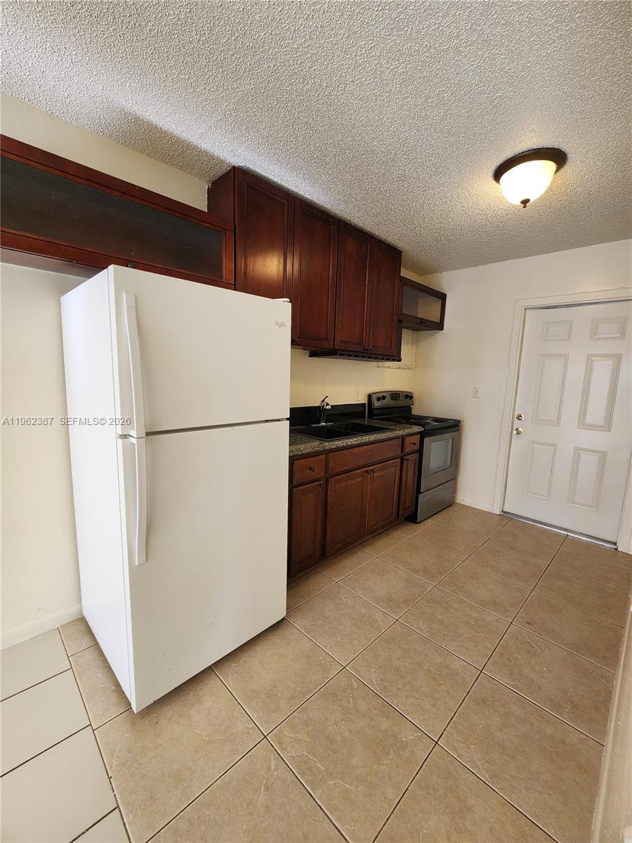 4131 Commercial Drive Sebring, FL 33870 - Photo 10 of 20 a kitchen with a refrigerator and a stove