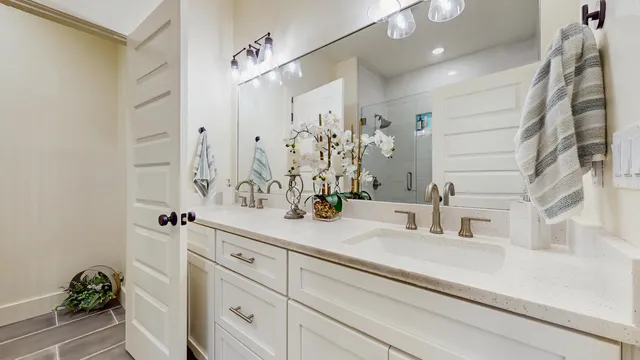 a bathroom with a sink and mirror with bathtub
