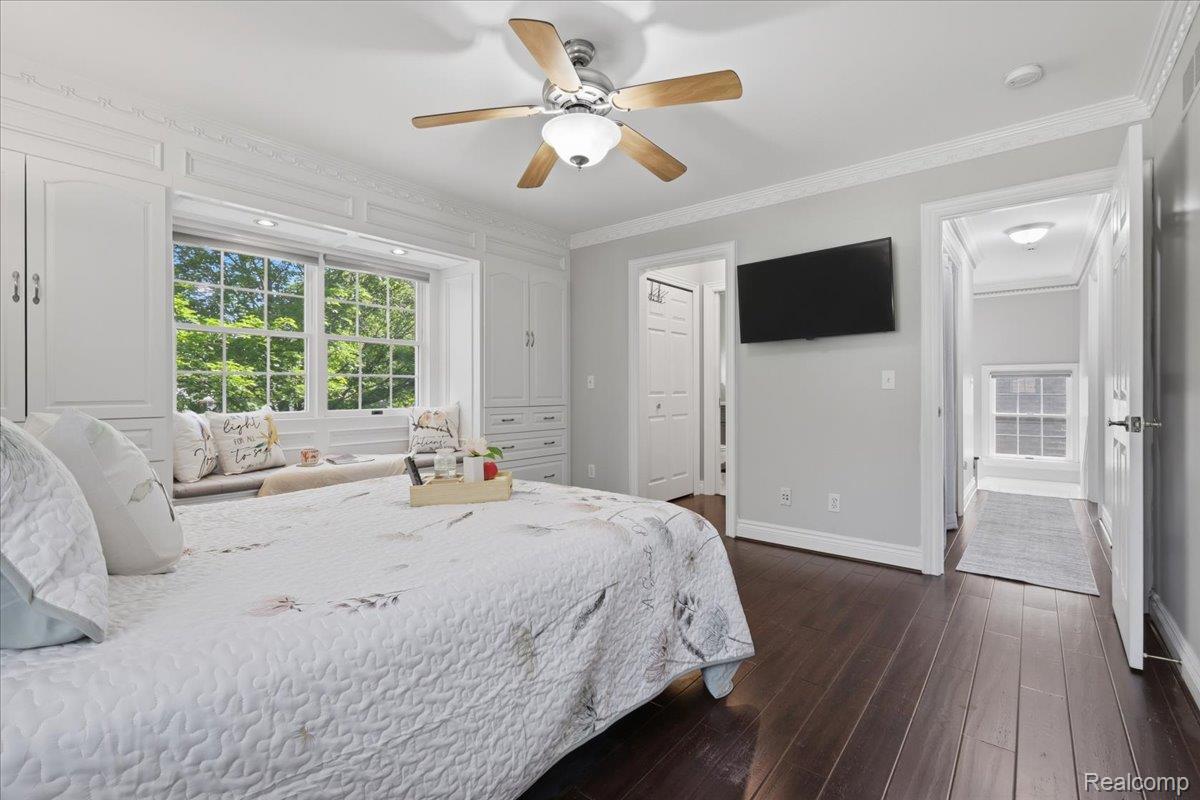 5685 Crescent Road Waterford, MI 48327 - Photo 25 of 47 Recessed window seat with built-in storage and upper cabinetry, hardwood flooring, detailed crown molding, and a ceiling fan with integrated lighting