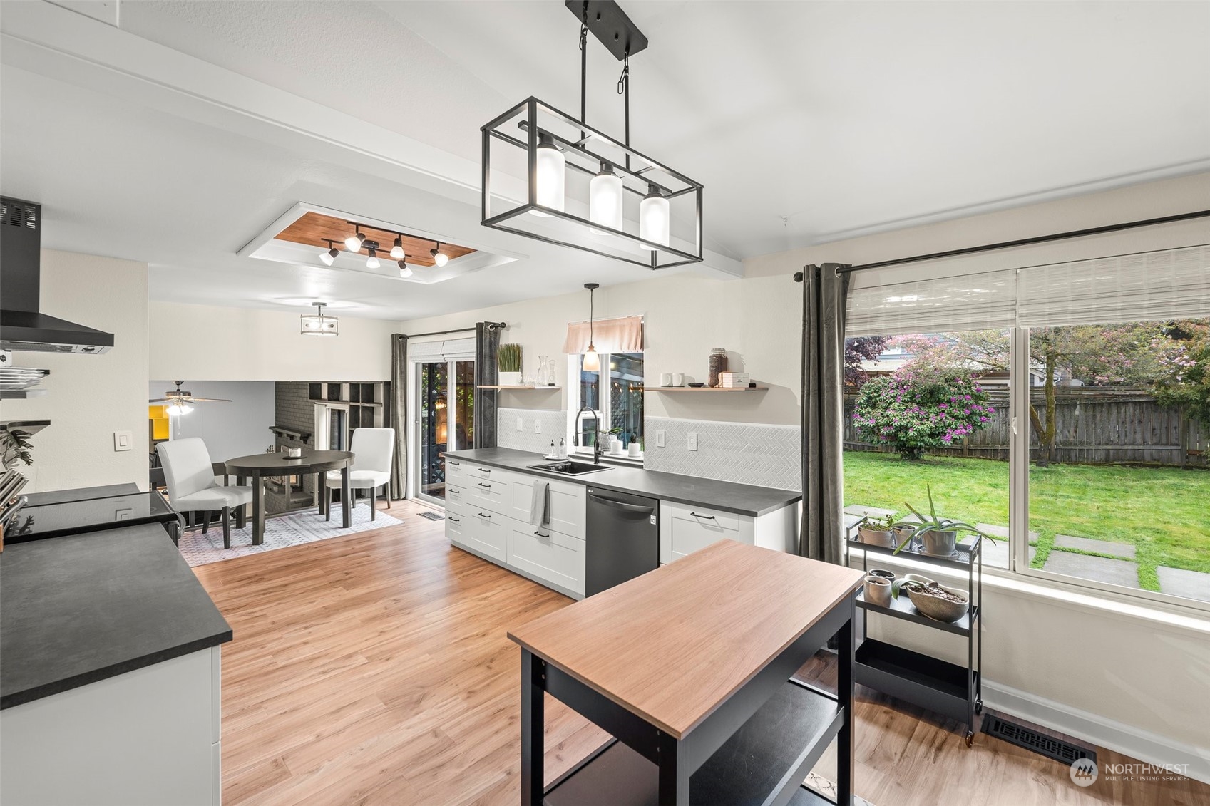66 Bonney Street Steilacoom, WA 98388 - Photo 14 of 40 a open kitchen with stainless steel appliances granite countertop a stove top oven a dining table and chairs with wooden floor