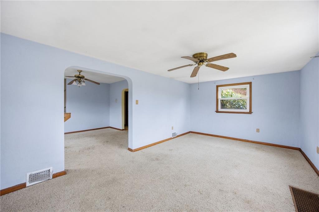 105 Pine Street Trafford, PA 15085 - Photo 10 of 22 an empty room with a ceiling fan and windows