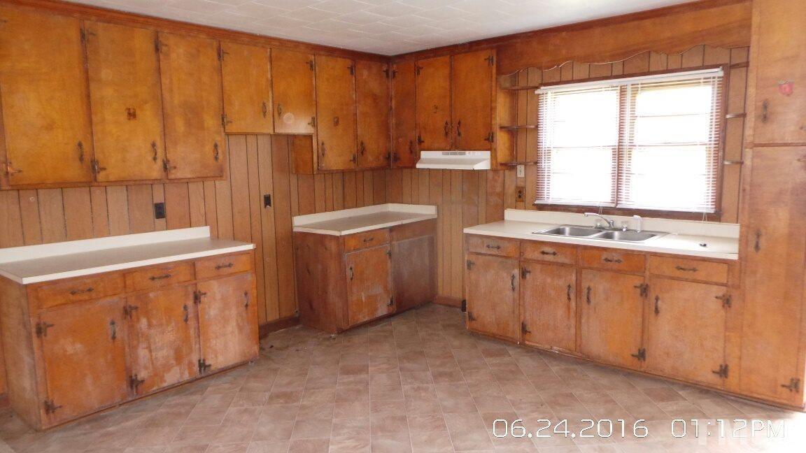 2401 Kittrell Road Kittrell, NC 27544 - Photo 4 of 14 a utility room with a sink a washer and dryer with wooden cabinets