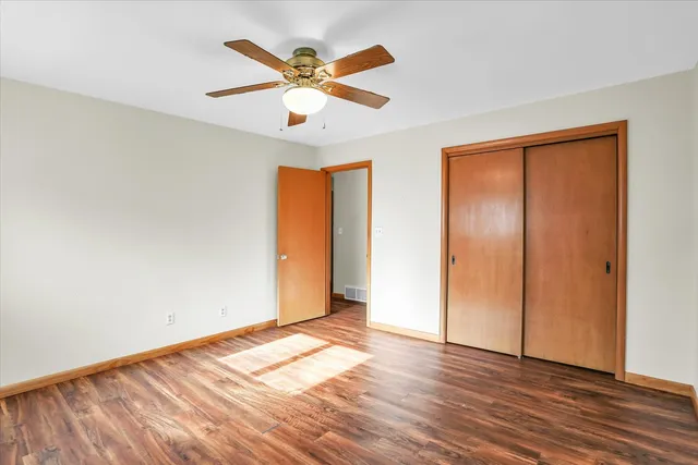 a view of a big room with wooden floor and a ceiling fan
