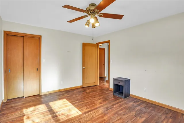 a view of an empty room with window and a ceiling fan