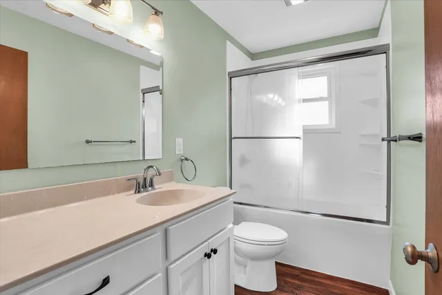 a bathroom with a sink a toilet a mirror and shower