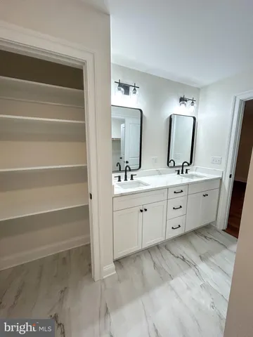 a spacious bathroom with a double vanity sink and a mirror