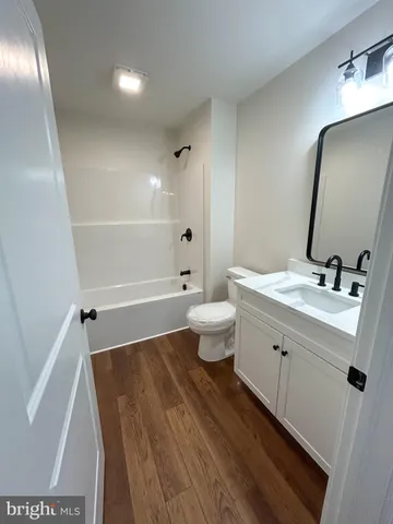 a bathroom with a double vanity sink toilet mirror and shower