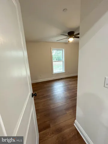 a view of hallway with stairs and wooden floor