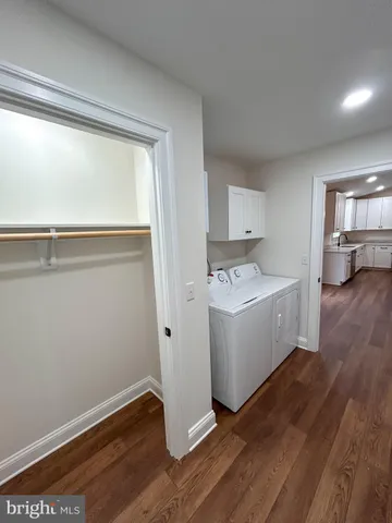 a view of utility room and bedroom with wooden floor