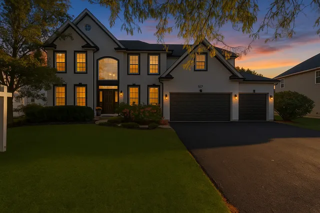 a front view of a house with a garden and yard