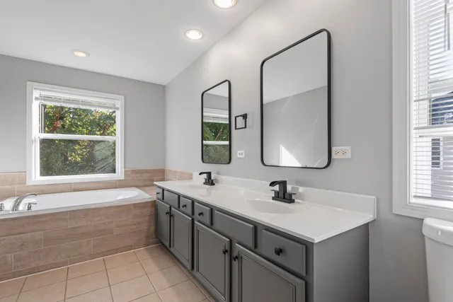 a bathroom with a sink and mirror with bathtub