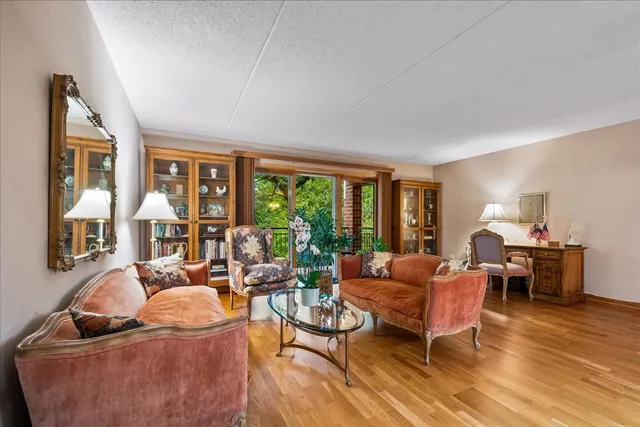 a living room with furniture floor to ceiling window and wooden floor