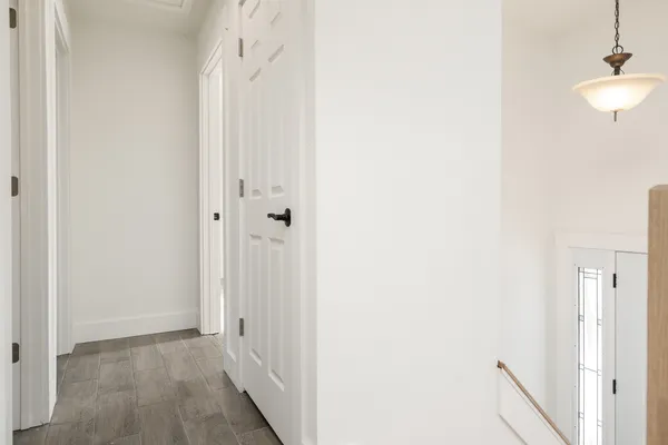 a view of a hallway with wooden floor