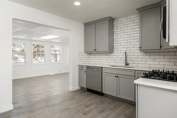 a kitchen with stainless steel appliances granite countertop a sink stove and cabinets