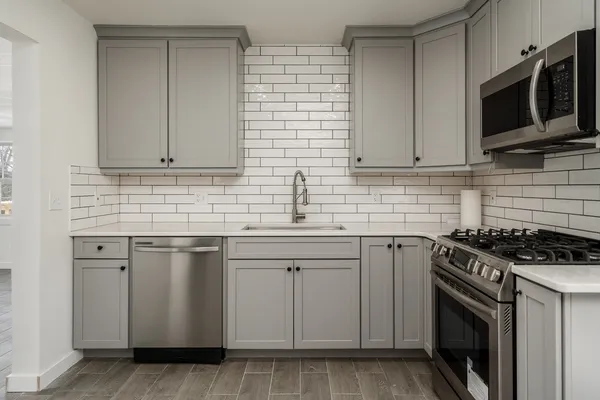 a kitchen with stainless steel appliances granite countertop a sink stove and microwave