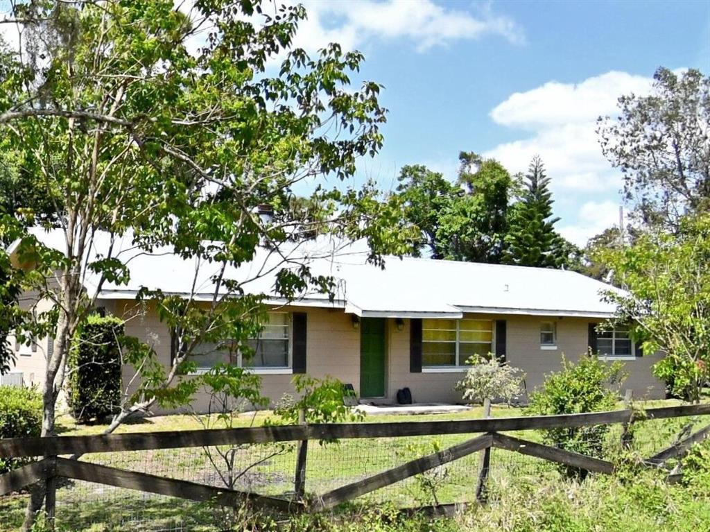 4898 Meadow Drive St. Cloud, FL 34772 - Photo 1 of 1 a front view of house with yard seating and green space