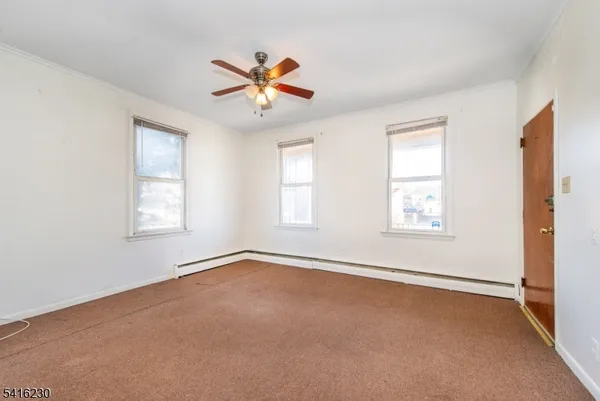 an empty room with windows and fan