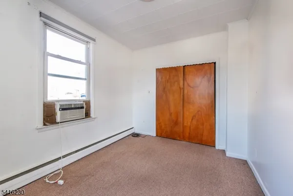 an empty room with windows and closet