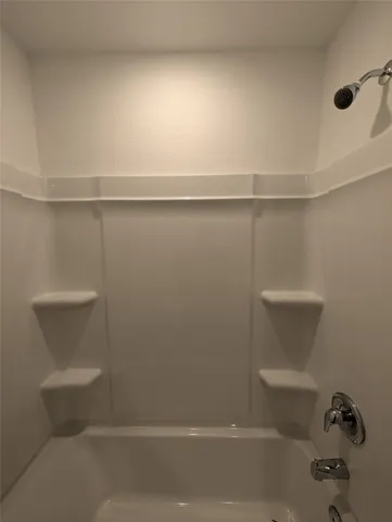 a view of a hallway with wooden floor and a bathroom