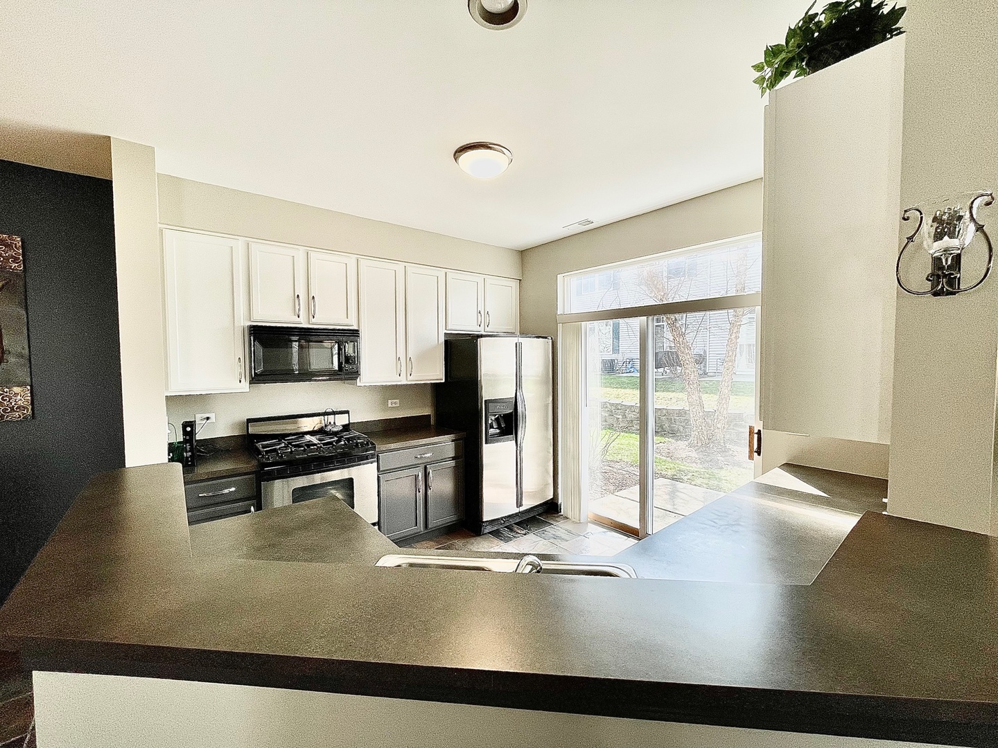 2902 Falling Waters Drive Lindenhurst, IL 60046 - Photo 7 of 14 a kitchen with stainless steel appliances a stove a refrigerator a sink and white cabinets with wooden floor