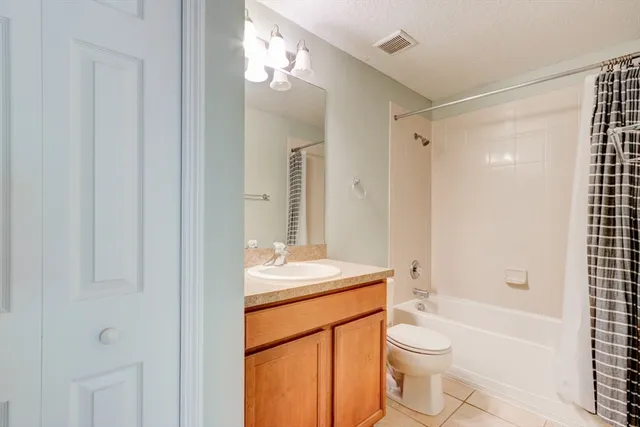 a bathroom with a sink a toilet a mirror and shower