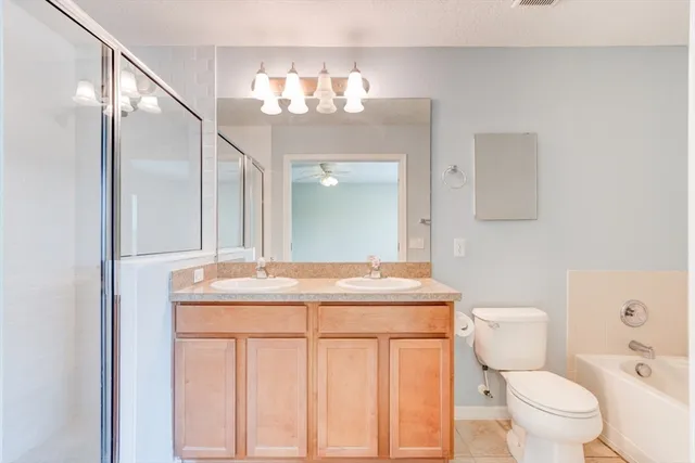 a bathroom with a granite countertop sink a toilet and a mirror