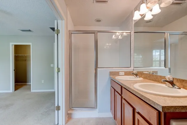 a bathroom with a granite countertop sink a mirror and a shower