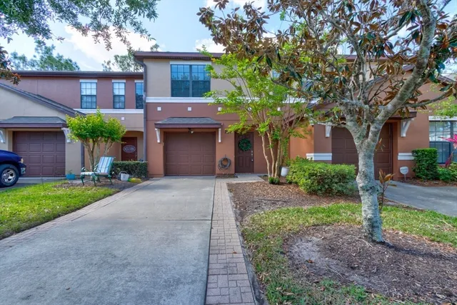 a front view of a house with a garden and trees