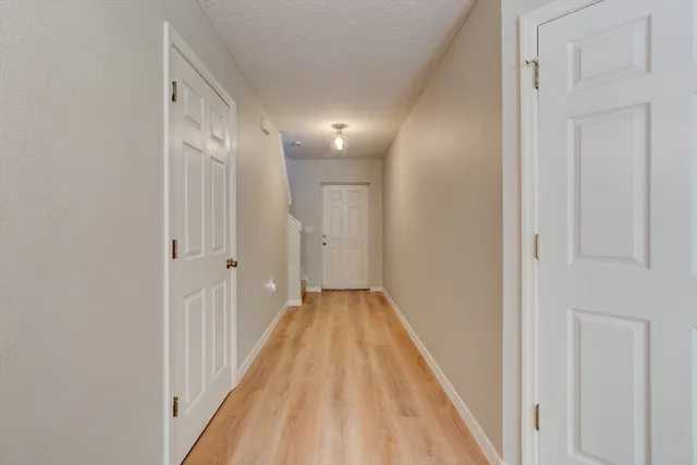a view of a hallway with wooden floor