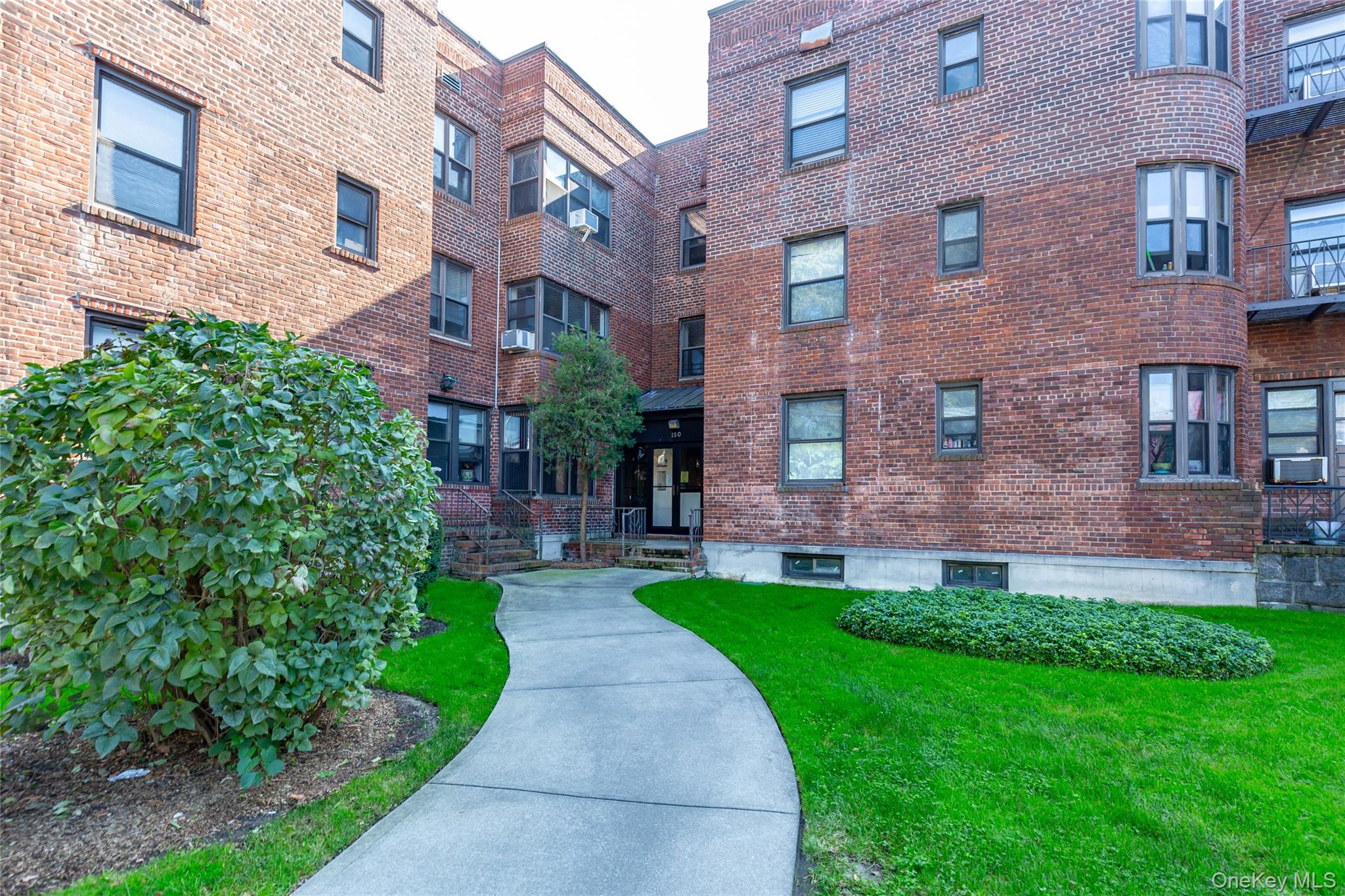 150 South Middle Neck Road, Unit 1B Great Neck, NY 11021 - Photo 1 of 1 a view of a brick building with a yard