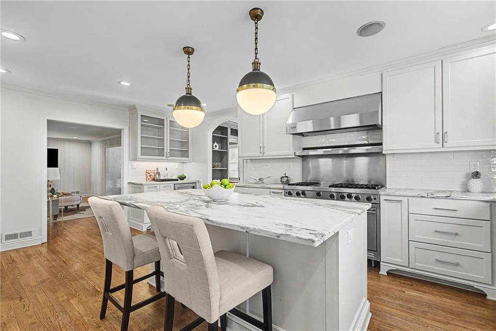 3819 North Stratford Road Northeast Atlanta, GA 30342 - Photo 12 of 48 a kitchen with stainless steel appliances a stove a sink a dining table and chairs