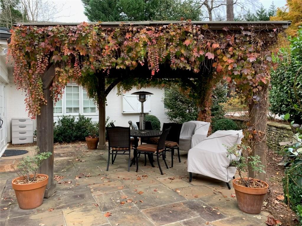 3819 North Stratford Road Northeast Atlanta, GA 30342 - Photo 46 of 48 a view of a patio with table and chairs potted plants and a large tree