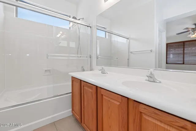 a bathroom with a granite countertop sink mirror and a bathtub