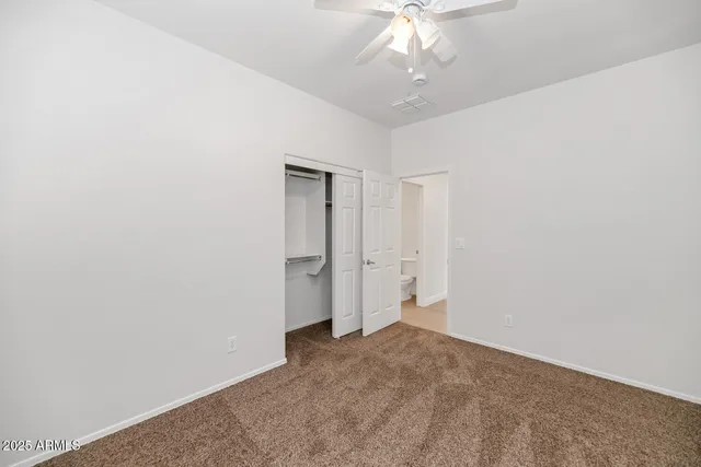 an empty room with a chandelier fan