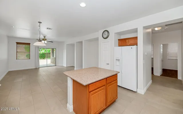 a view of an empty room and window and kitchen