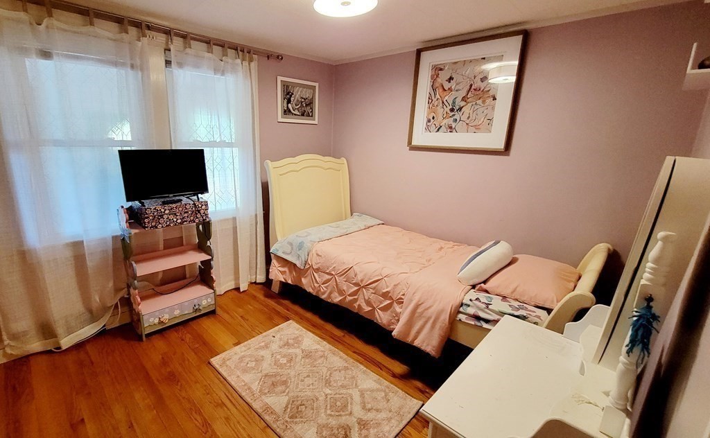 11 North Martin Road Amesbury, MA 01913 - Photo 16 of 28 a bedroom with a bed and wooden floor