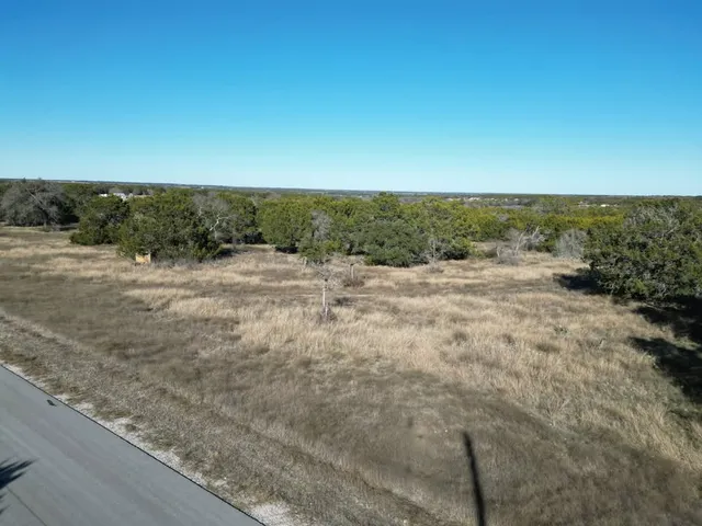 a view of dirt road with a building in the background