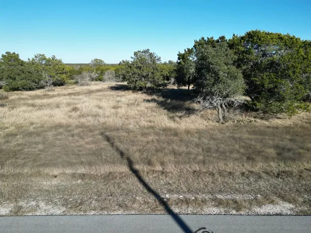 a view of a dry yard with wooden fence