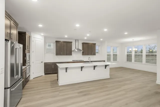 a kitchen with stainless steel appliances a refrigerator sink and microwave
