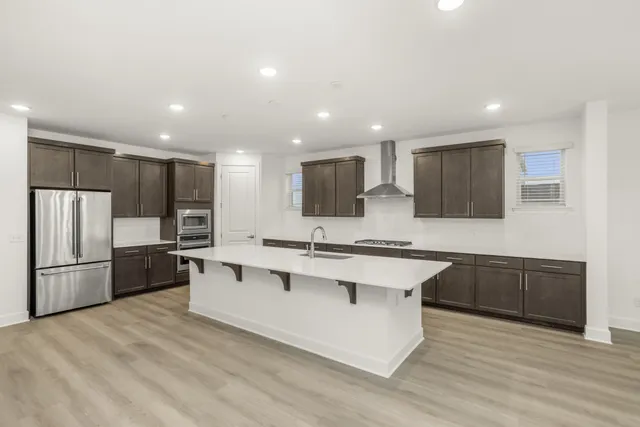 a kitchen with stainless steel appliances granite countertop a sink stove and refrigerator