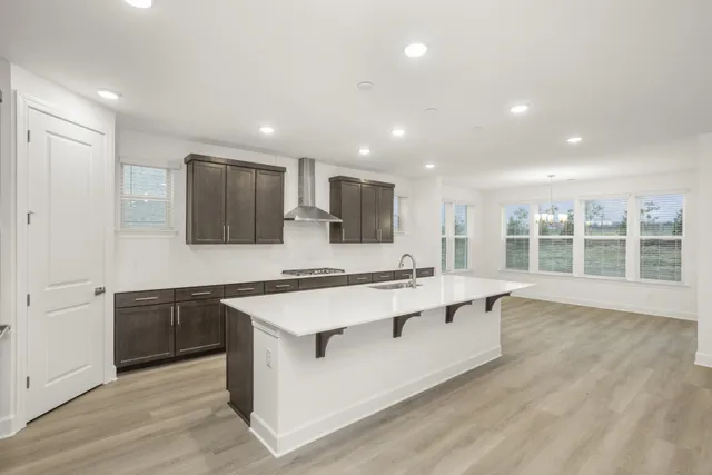 a large white kitchen with wooden floors and stainless steel appliances