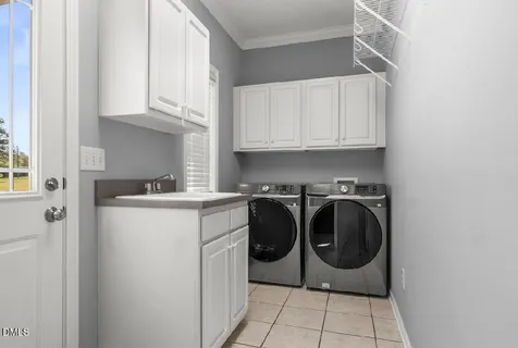 a utility room with sink dryer and washer