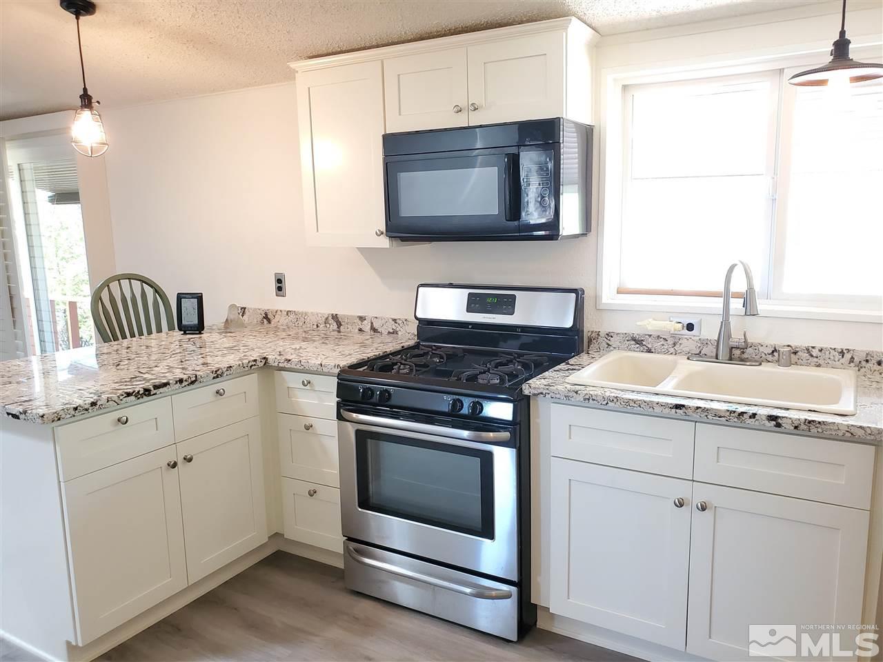 1145 Antelope Road Reno, NV 89506 - Photo 3 of 32 a kitchen with granite countertop cabinets stainless steel appliances and sink
